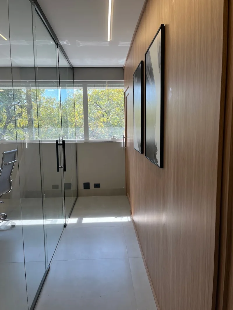Corredor do escritório com divisória de vidro e painel de madeira
